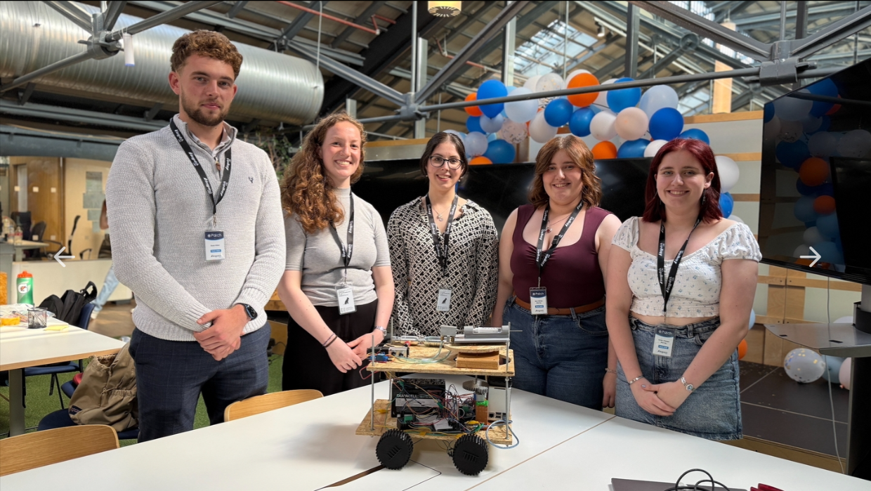 Team of five standing behind the Lynra rover on a table at Patch Demo Day 2025.